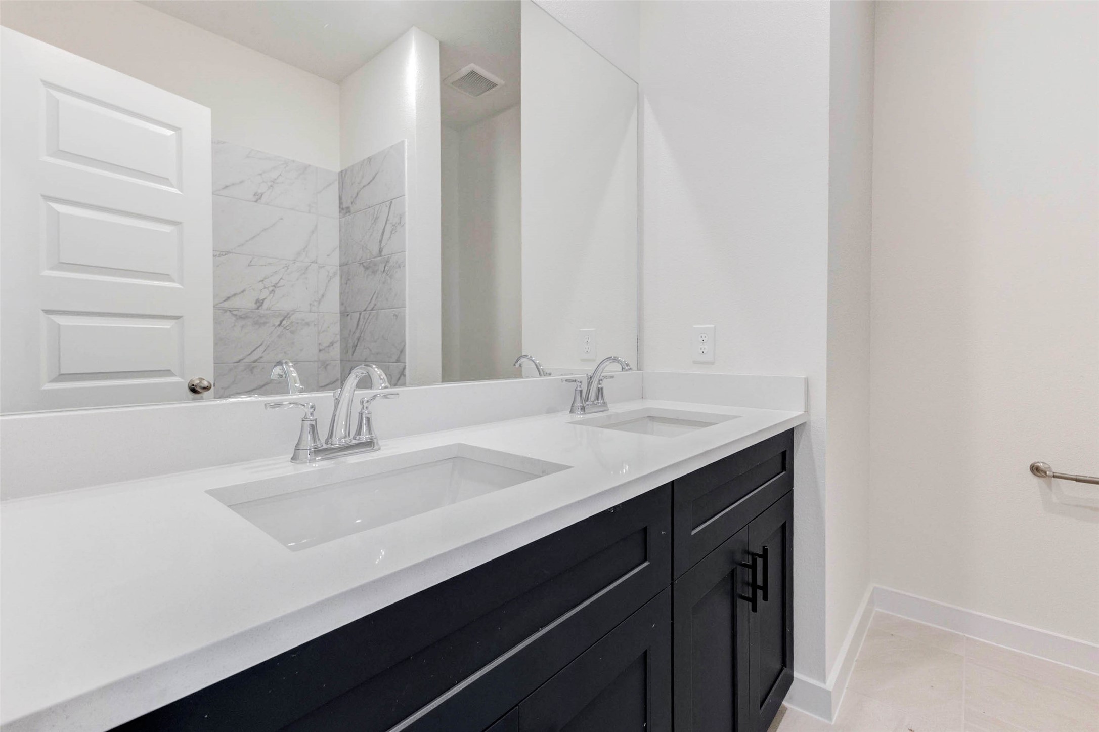 1131 Santee Court Rosharon, TX 77583 - Photo 20 of 31 Contemporary and practical, the shared upstairs bathroom includes a dual-sink vanity with quartz countertops and sleek black cabinetry perfect for morning routines with style and storage to spare.