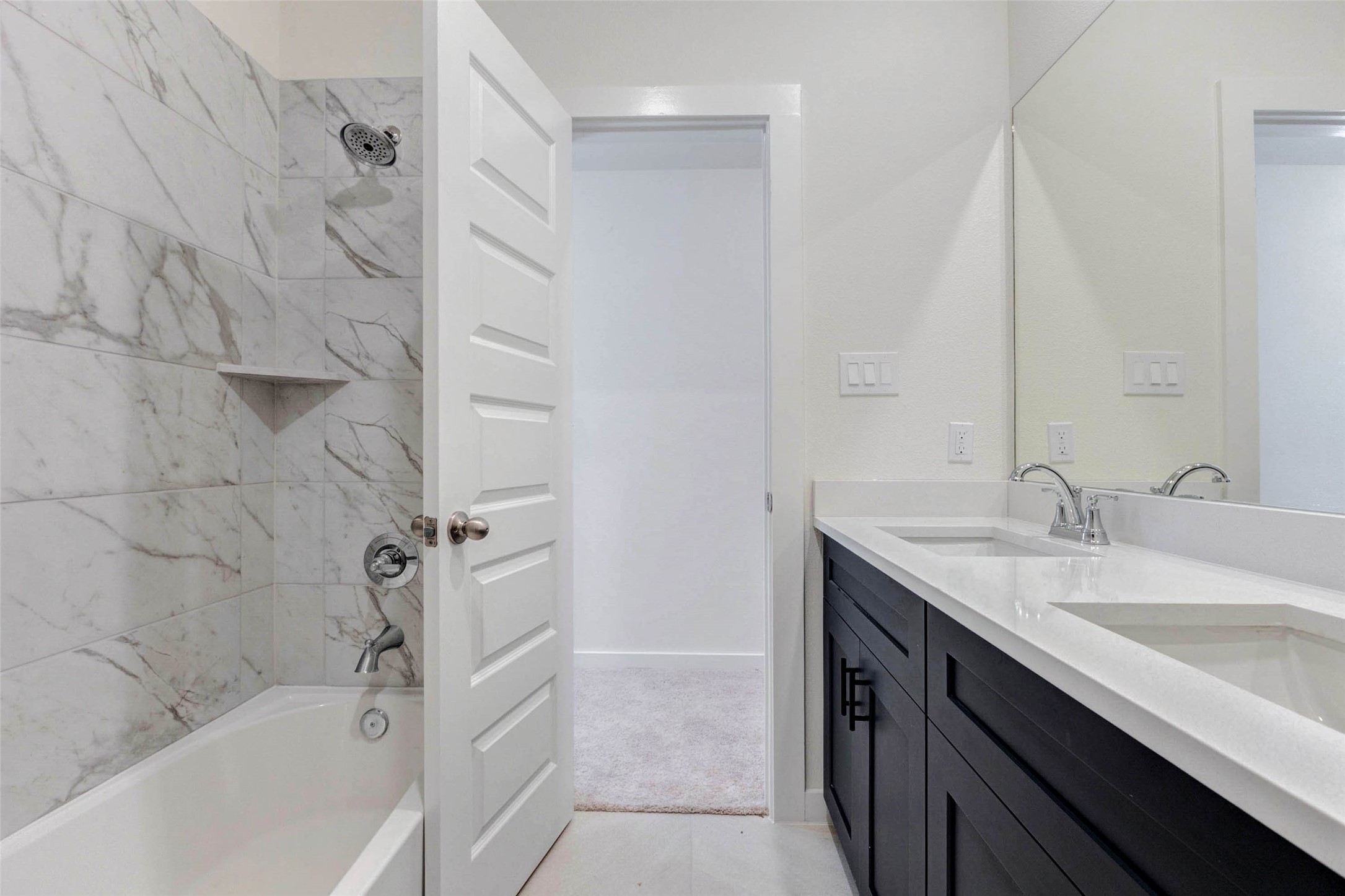 1131 Santee Court Rosharon, TX 77583 - Photo 21 of 31 This full bathroom features a stylish marble-look tiled tub and shower combo, with modern fixtures and designer finishes. Located between two bedrooms, it’s built for convenience, comfort, and clean lines.