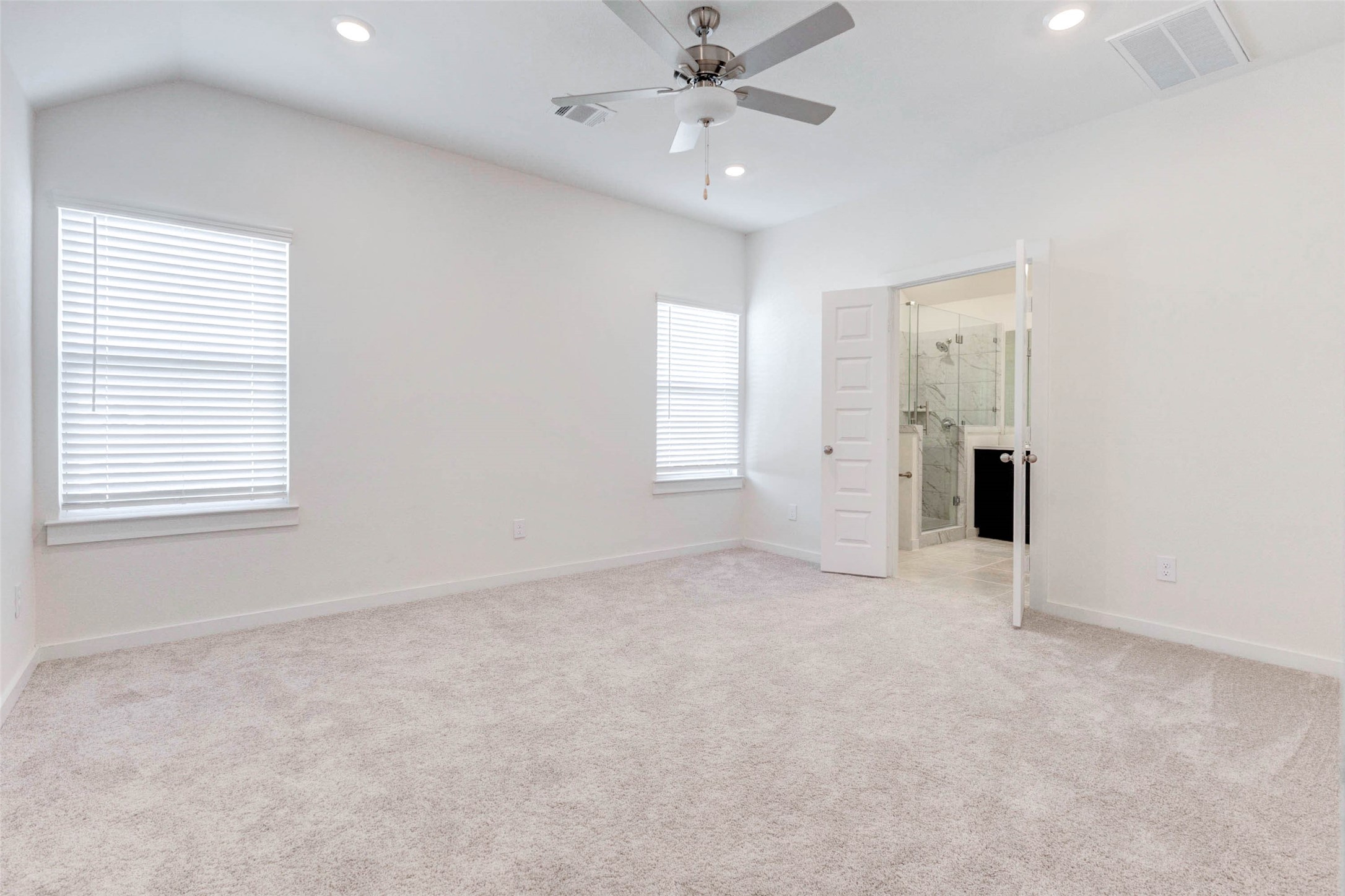 1131 Santee Court Rosharon, TX 77583 - Photo 23 of 31 The spacious primary suite delivers comfort and calm with plush carpeting, a ceiling fan, and ample natural light from dual windows. A private en-suite bath with dual sinks and a glass shower awaits just beyond the double doors.