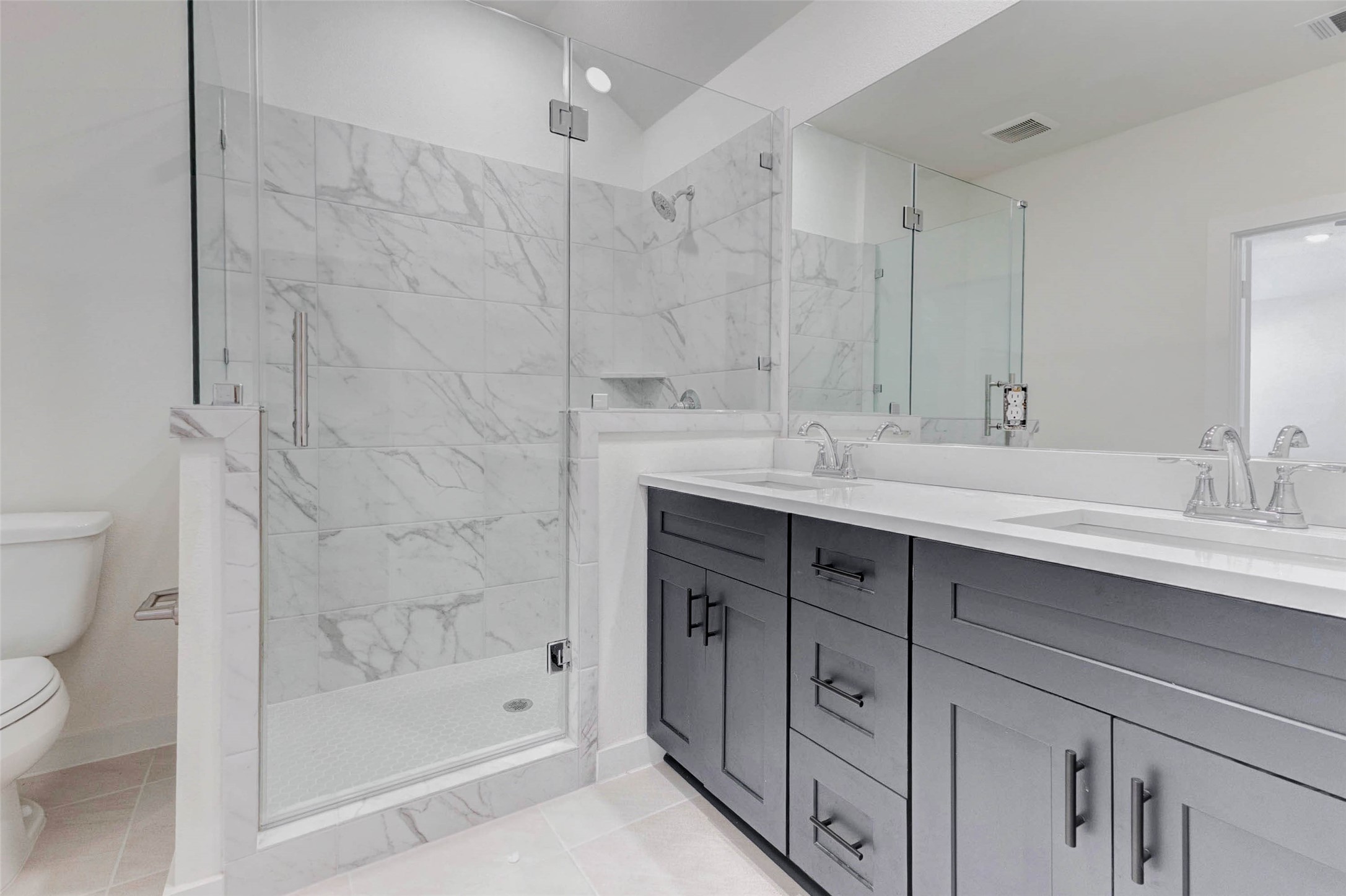 1131 Santee Court Rosharon, TX 77583 - Photo 26 of 31 Experience a spa-inspired start to your day in this oversized frameless glass shower. Marble-look tile surrounds provide timeless style, while sleek fixtures and a dual-sink vanity offer functionality with elevated design.