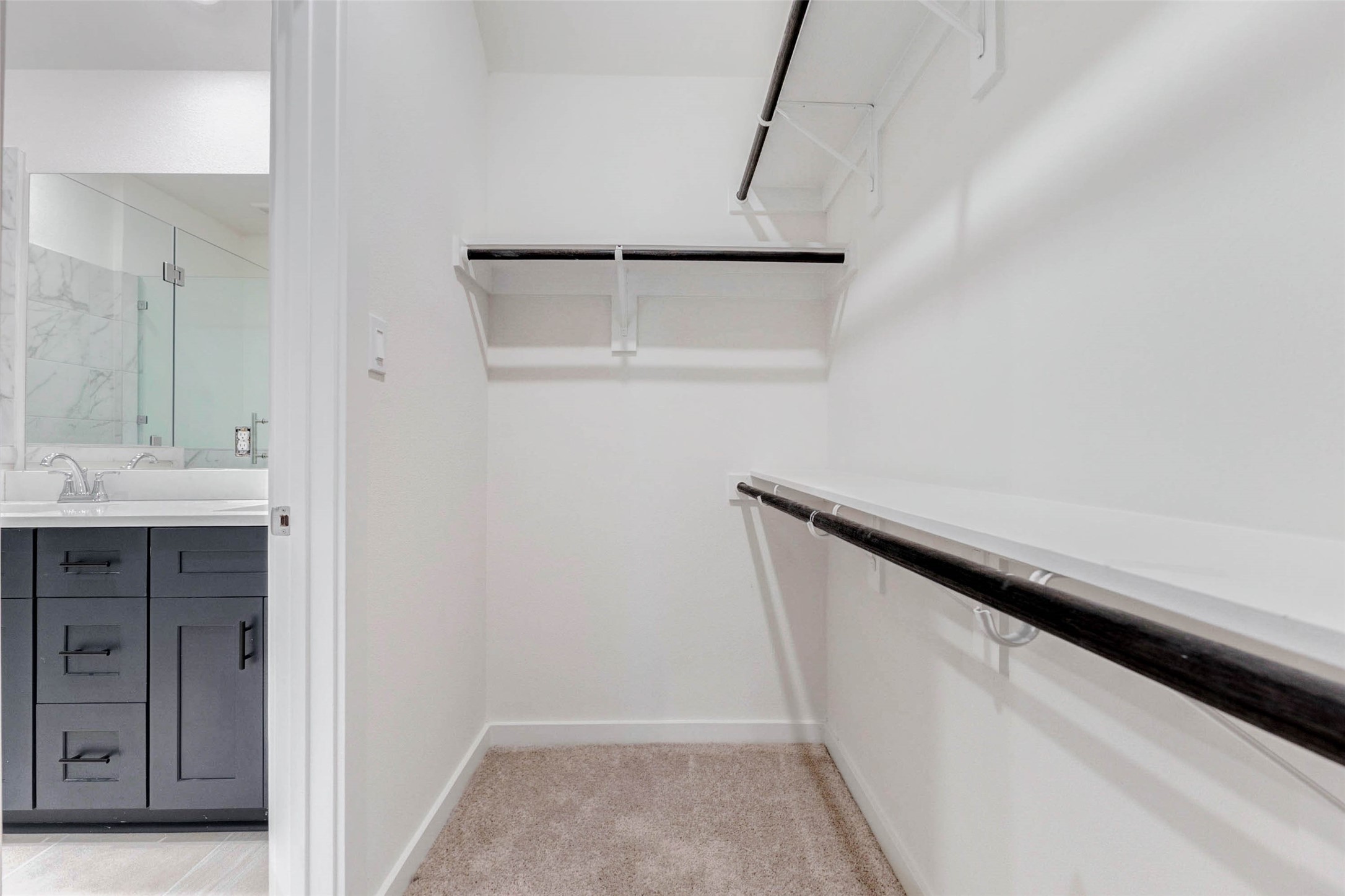 1131 Santee Court Rosharon, TX 77583 - Photo 27 of 31 Storage made stylish this walk-in closet features double-tiered hanging rods and upper shelving for maximum organization. Located just off the primary bath, it provides ample space for wardrobes and accessories.