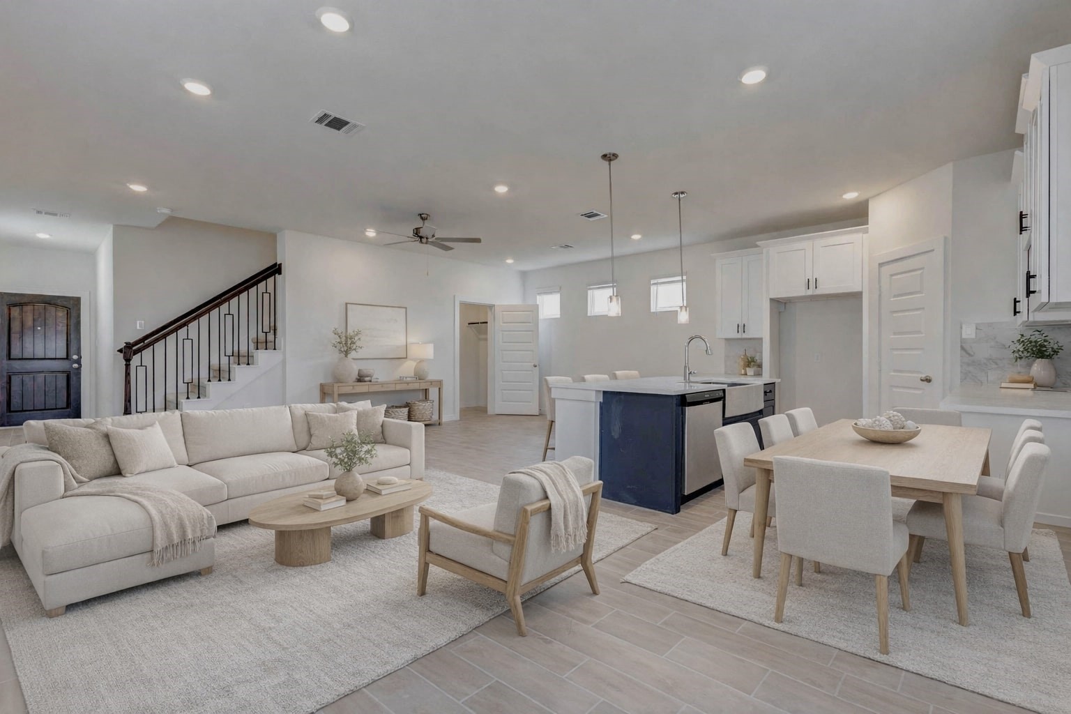 1131 Santee Court Rosharon, TX 77583 - Photo 3 of 31 From the front door, enjoy a full view of the heart of the home. The staircase with wrought iron spindles adds character, while the kitchen features stunning white cabinetry, stainless steel appliances, and a navy island with quartz countertops ideal for entertaining. This photo has been virtually staged for visual reference.