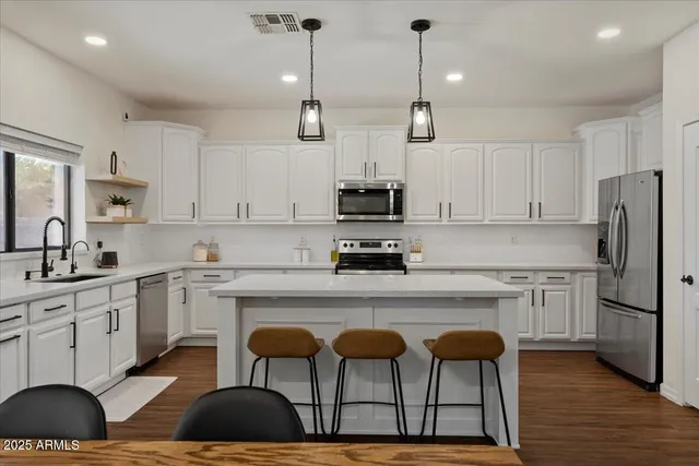 a kitchen with white cabinets and sink