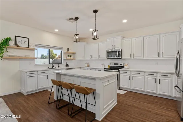 a view of a dining room and livingroom with furniture wooden floor a chandelier