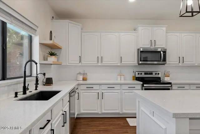 a view of a workspace with furniture and a window