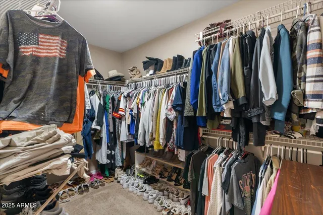 a bedroom with a bed and a flat tv screen on the dresser