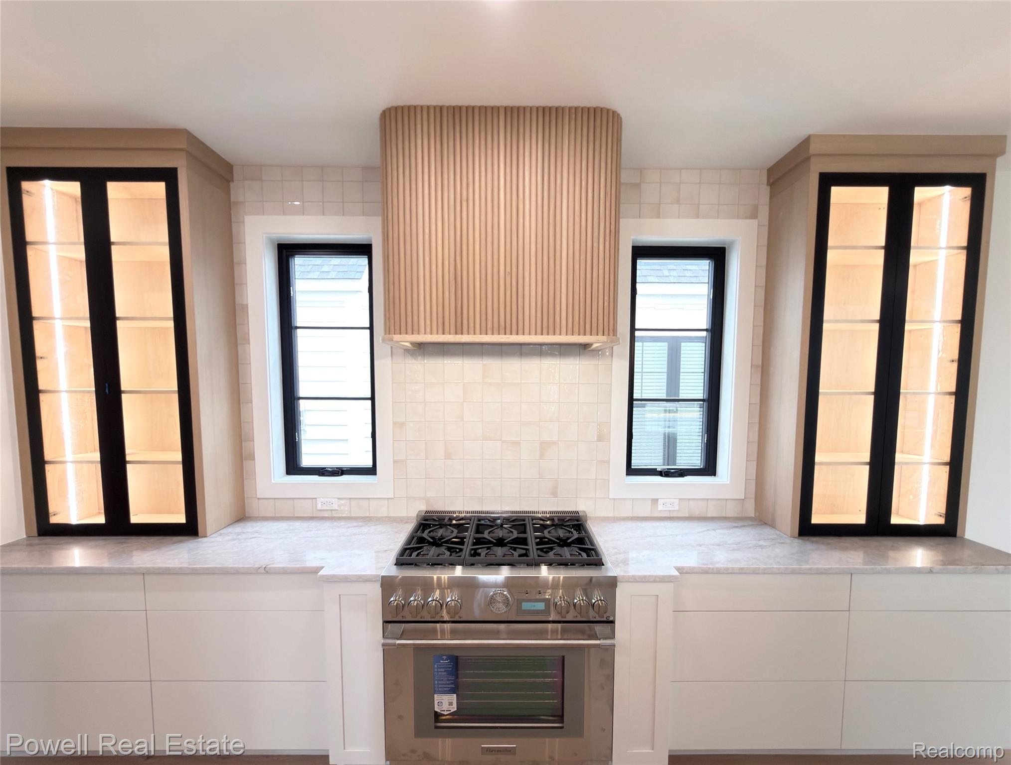 1998 Hazel Street Birmingham, MI 48009 - Photo 6 of 22 Modern kitchen featuring a stainless steel range with a built-in oven, a custom wood-slat range hood, and a tiled backsplash