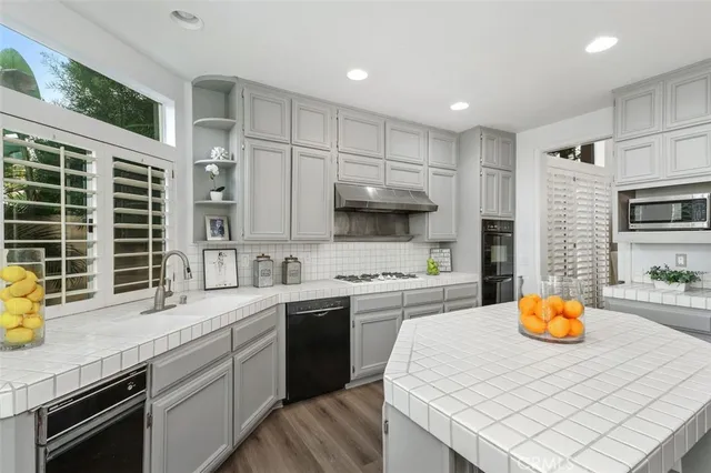 a kitchen with stainless steel appliances a stove a sink a microwave a refrigerator and cabinets