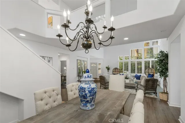 a view of a dining room with furniture a chandelier and wooden floor