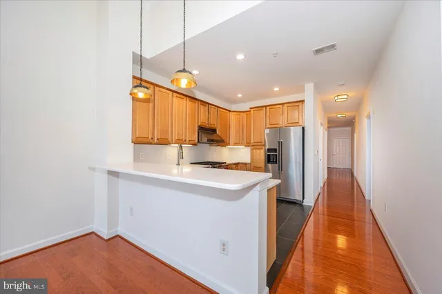 a kitchen with stainless steel appliances granite countertop a sink a stove and a refrigerator