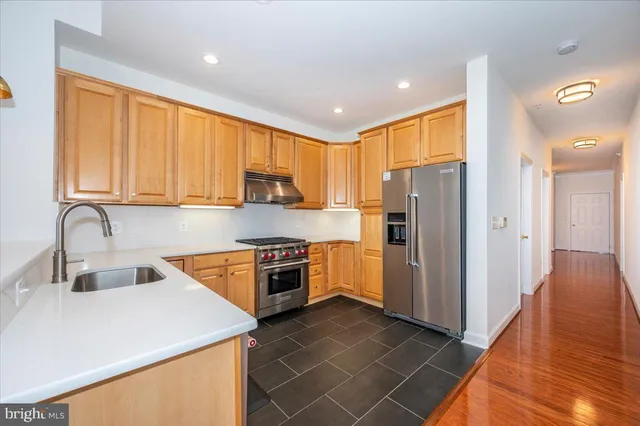 a kitchen with stainless steel appliances granite countertop a refrigerator sink and stove