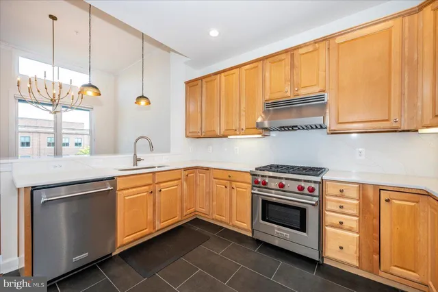 a kitchen with stainless steel appliances granite countertop a sink a stove and cabinets
