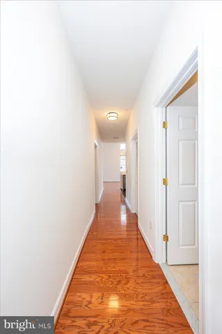 a view of a hallway with wooden floor