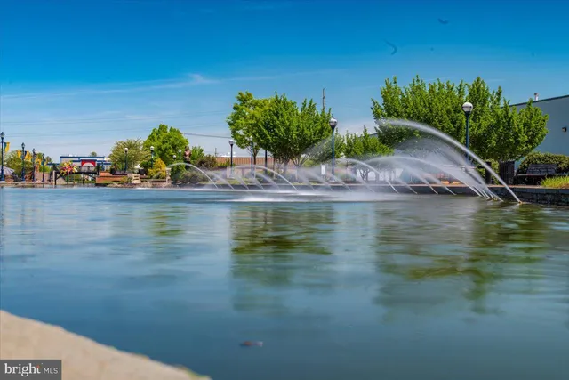 a view of swimming pool with outdoor seating and trees in the background