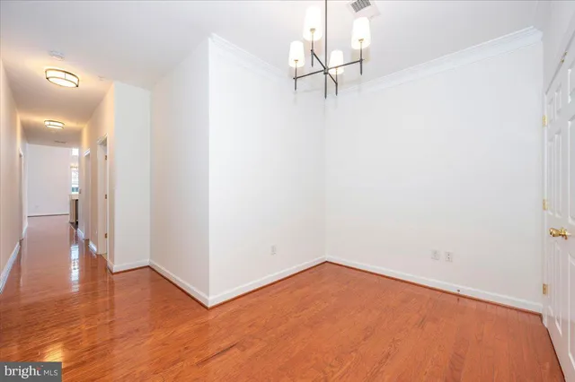 a view of a room with wooden floor and a ceiling fan
