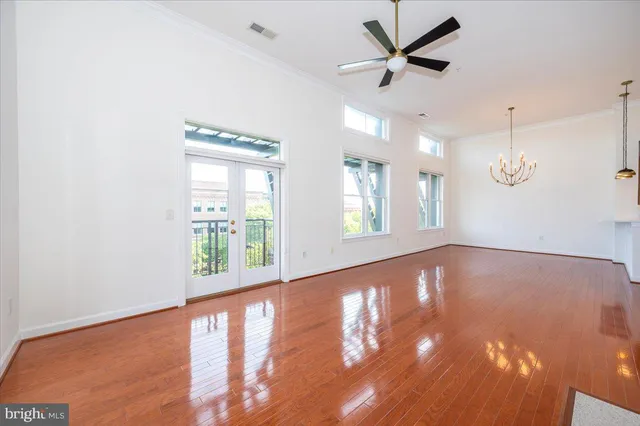 a view of an empty room with window and a kitchen
