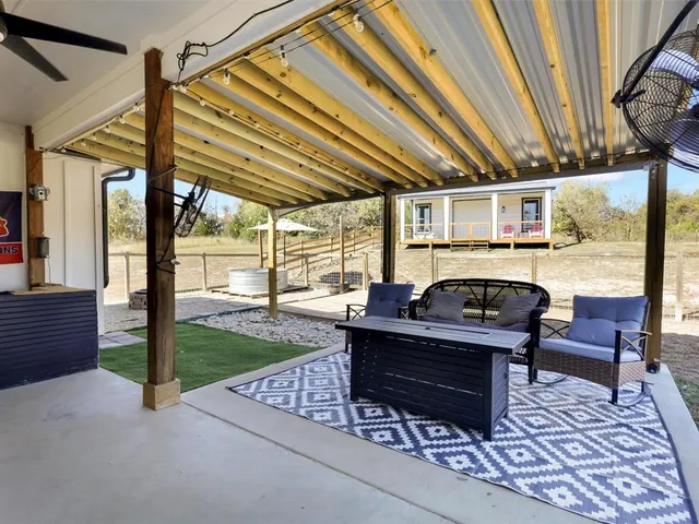 a view of a house with backyard and sitting area