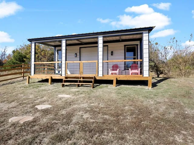 a living room with a table chairs and a flat screen tv