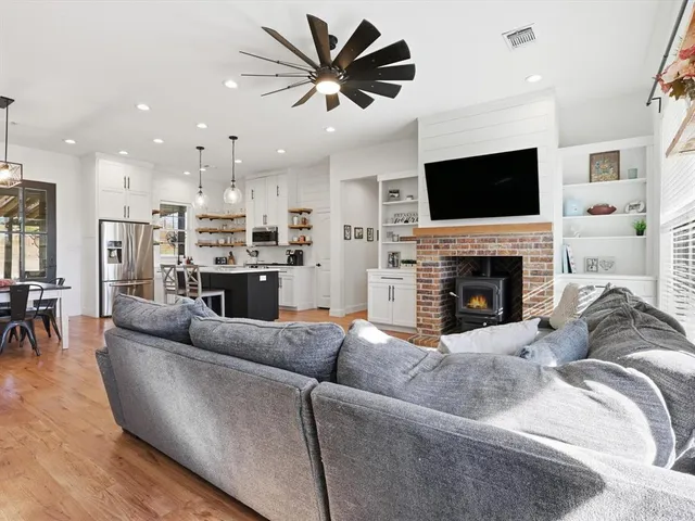 a living room with furniture a flat screen tv and a fireplace