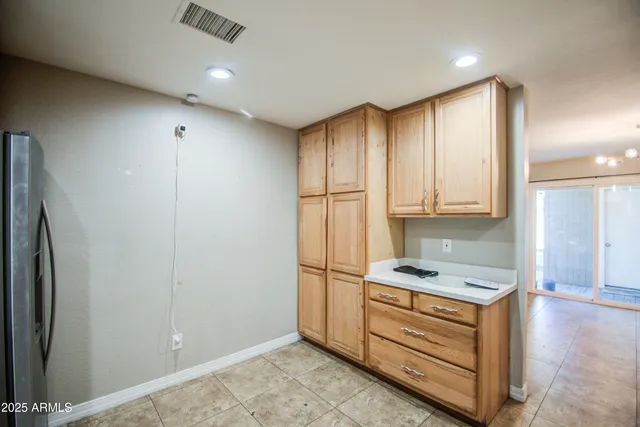 a view of an empty room with a chandelier fan