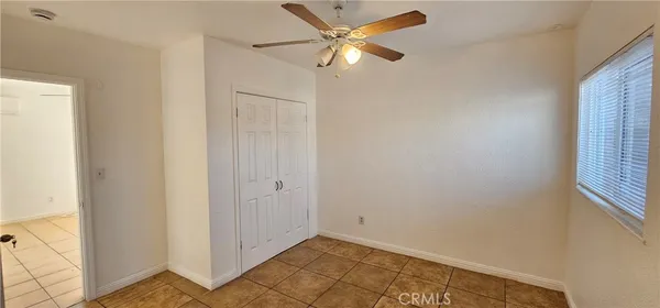 an empty room with a window and a ceiling fan