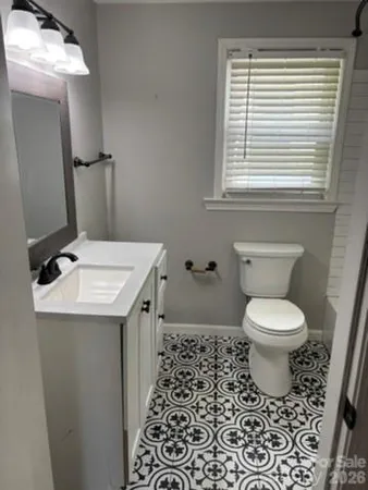 a bathroom with a toilet a sink and a window
