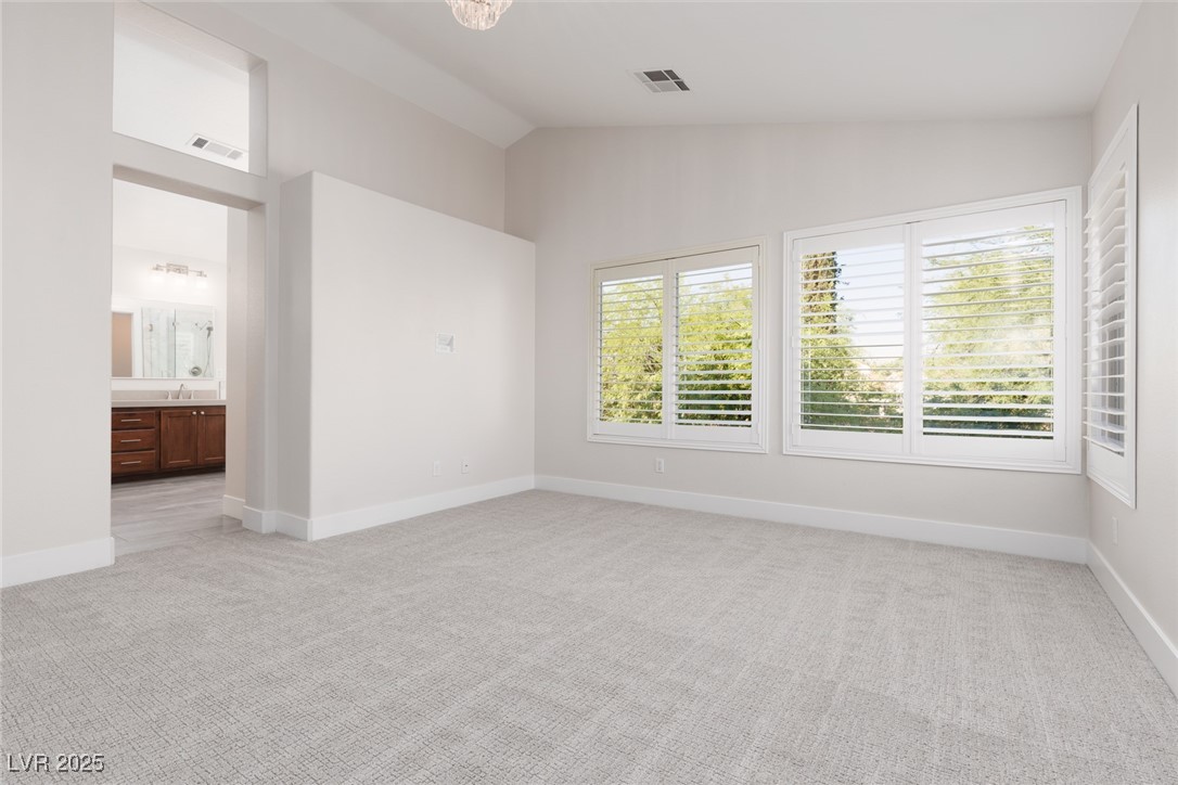 7837 Fort Ruby Place Las Vegas, NV 89128 - Photo 16 of 50 Unfurnished bedroom featuring light colored carpet, connected bathroom, and high vaulted ceiling