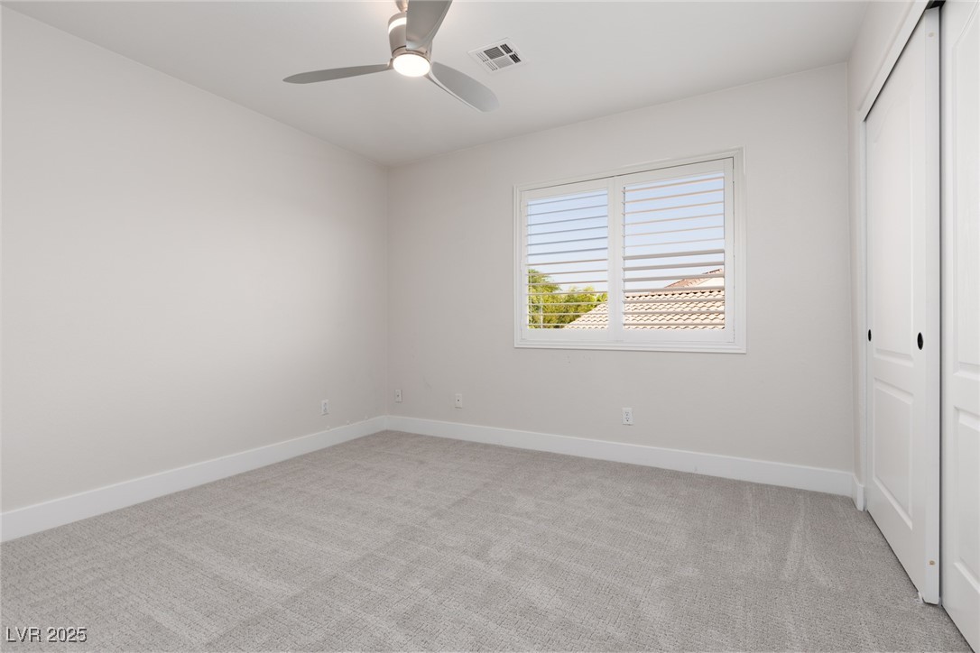 7837 Fort Ruby Place Las Vegas, NV 89128 - Photo 24 of 50 Unfurnished bedroom featuring light carpet, a closet, and ceiling fan
