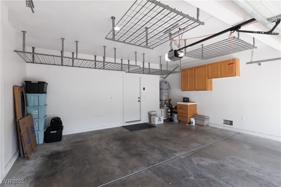7837 Fort Ruby Place Las Vegas, NV 89128 - Photo 29 of 50 Garage with a garage door opener, water heater, and baseboards