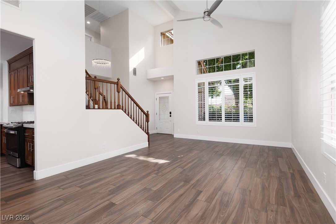 7837 Fort Ruby Place Las Vegas, NV 89128 - Photo 3 of 50 Foyer featuring stairs, a ceiling fan, dark wood finished floors, high vaulted ceiling, and baseboards