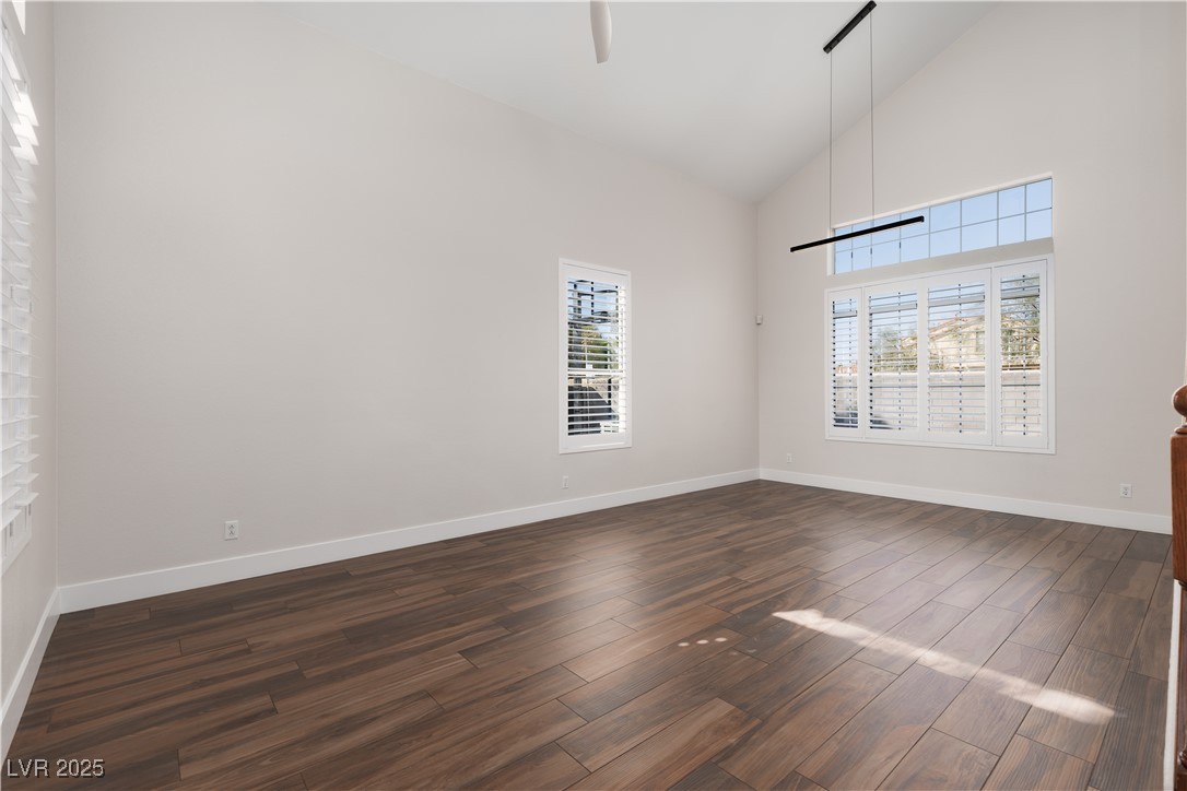 7837 Fort Ruby Place Las Vegas, NV 89128 - Photo 6 of 50 Empty room featuring dark wood-type flooring, high vaulted ceiling, and baseboards