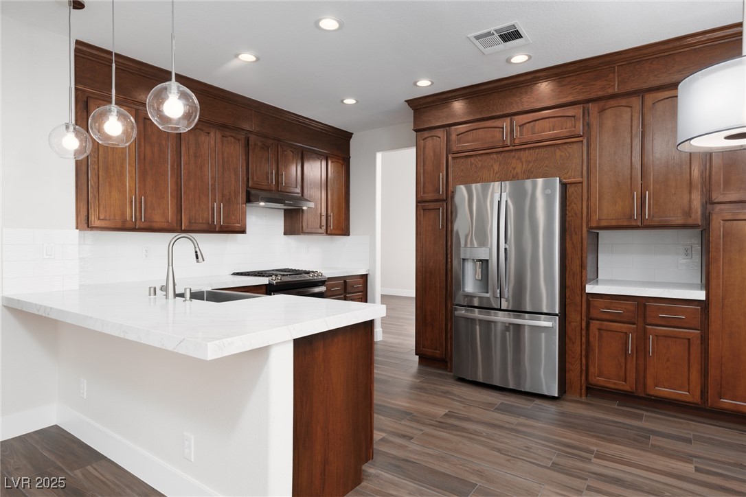 7837 Fort Ruby Place Las Vegas, NV 89128 - Photo 7 of 50 Kitchen with backsplash, pendant lighting, appliances with stainless steel finishes, a peninsula, and recessed lighting
