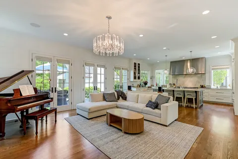 a living room with furniture a bookshelf and a large window