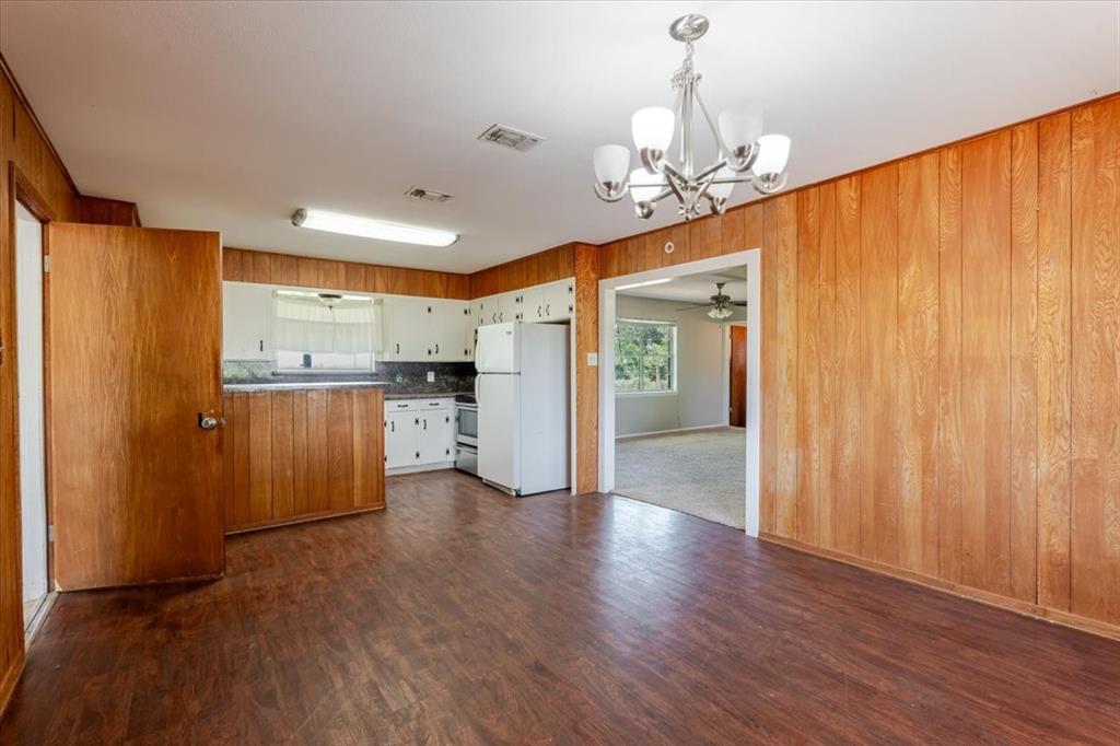 306 Grindstone Road Weatherford, TX 76087 - Photo 6 of 18 a view of a kitchen with a refrigerator wooden floor and windows