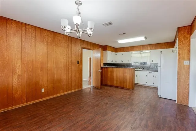 a view of a kitchen with granite countertop wooden floor and stainless steel appliances