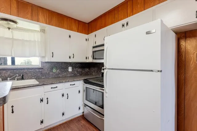 a kitchen with appliances a sink and cabinets