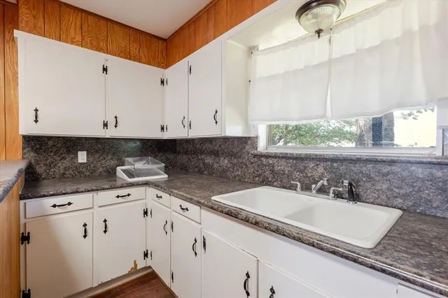 a kitchen with granite countertop white cabinets and white appliances