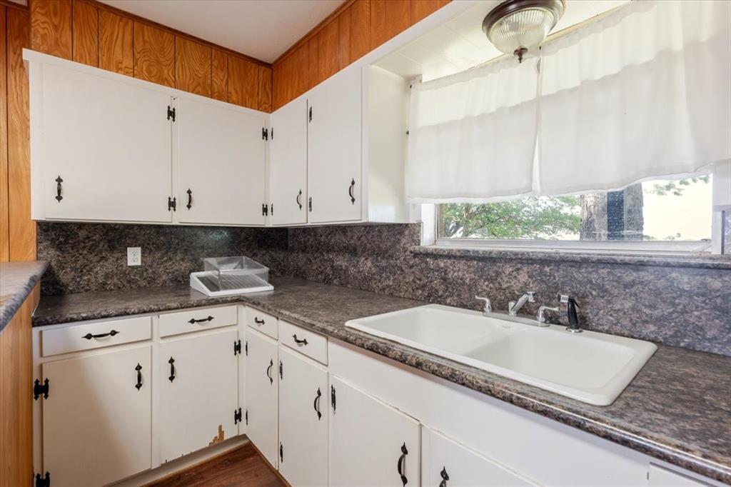 306 Grindstone Road Weatherford, TX 76087 - Photo 9 of 18 a kitchen with granite countertop white cabinets and white appliances