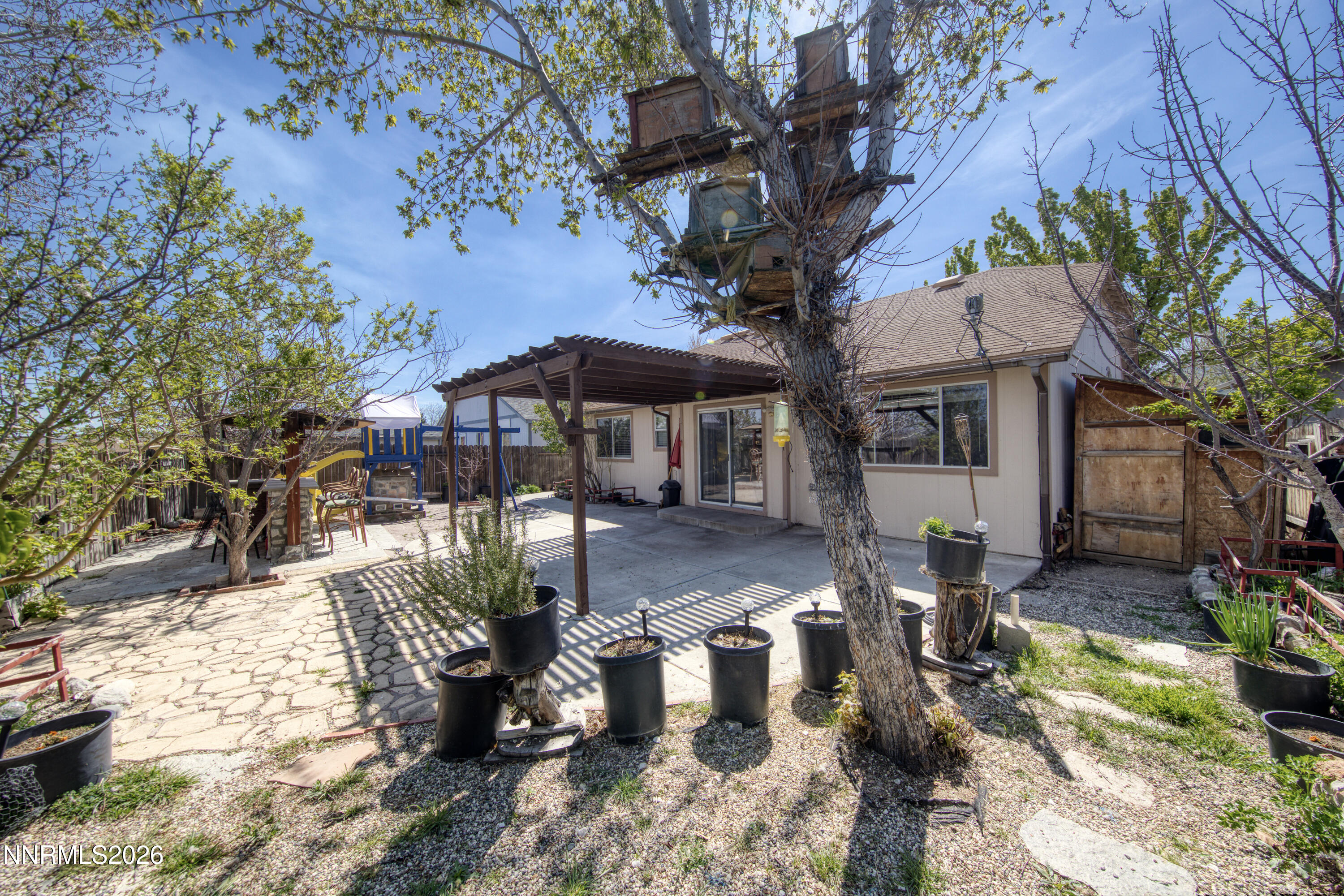 7951 Big River Drive Reno, NV 89506 - Photo 23 of 30 a view of a patio with table and chairs potted plants and large tree