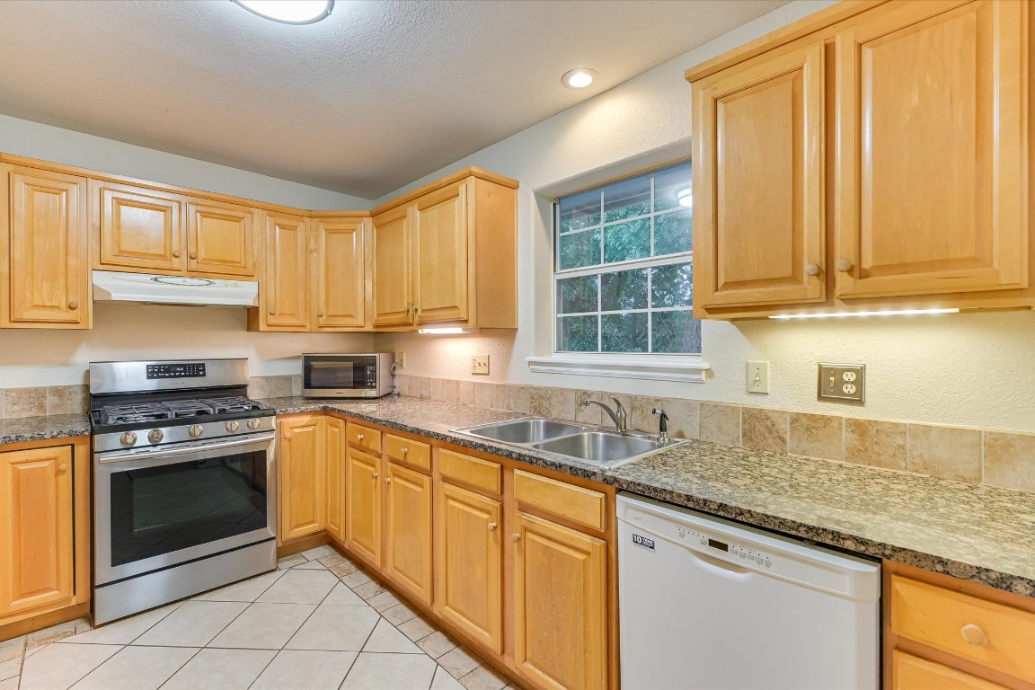 2405 Bahama Road Austin, TX 78733 - Photo 4 of 38 Kitchen with granite countertops. All appliances convey. That includes the refrigerator, washer, and dryer.