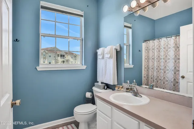 a bathroom with a sink vanity mirror and toilet