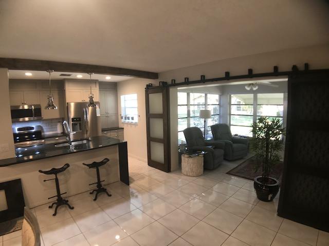 a room with lots of tables a large window and chairs