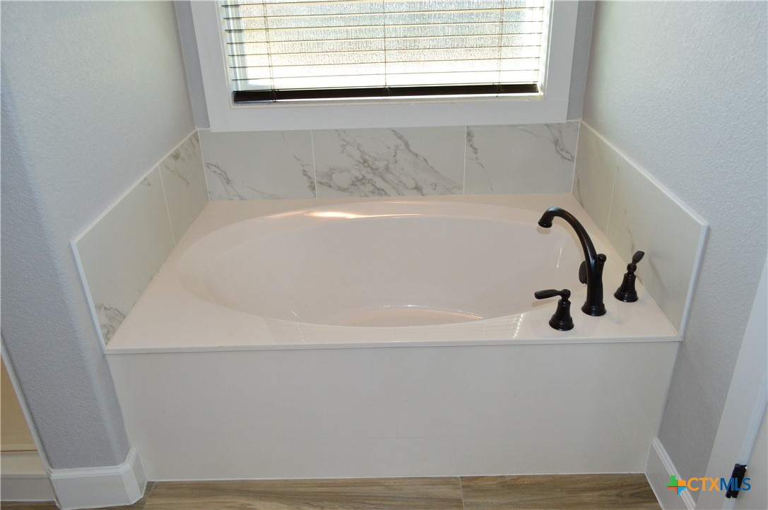 1026 County Road 3152 Kempner, TX 76539 - Photo 21 of 48 Master Bath Oval Soaker Tub ** The master bath has granite countertops with two individual sink areas, framed mirrors, soaker tub, separate shower and private water closet.