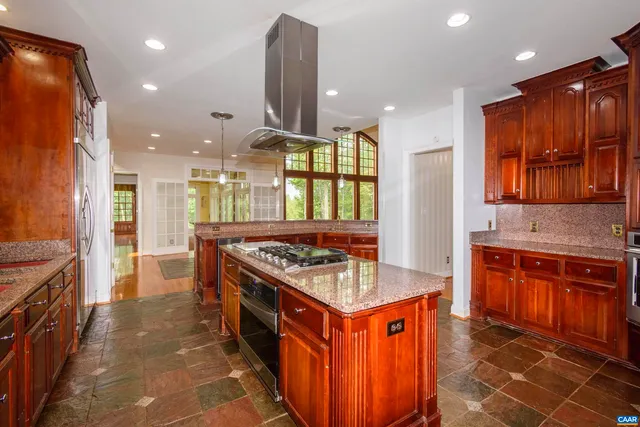 a kitchen with stainless steel appliances granite countertop a stove a refrigerator and a dining table