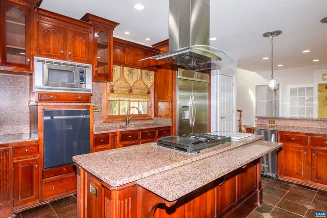 a kitchen with stainless steel appliances granite countertop a stove a sink and a refrigerator