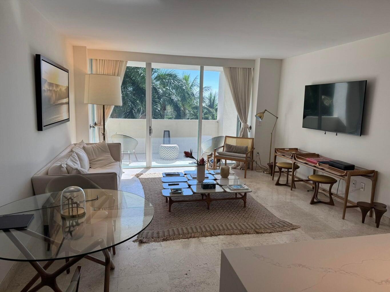 3400 Southwest 27th Avenue, Unit 303 Miami, FL 33133 - Photo 2 of 12 a living room with furniture and a flat screen tv