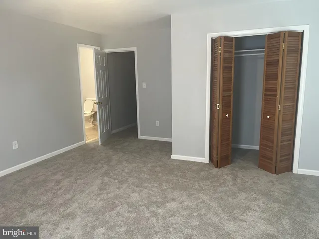an empty room with windows and closet