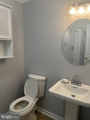 a bathroom with a toilet a sink and mirror