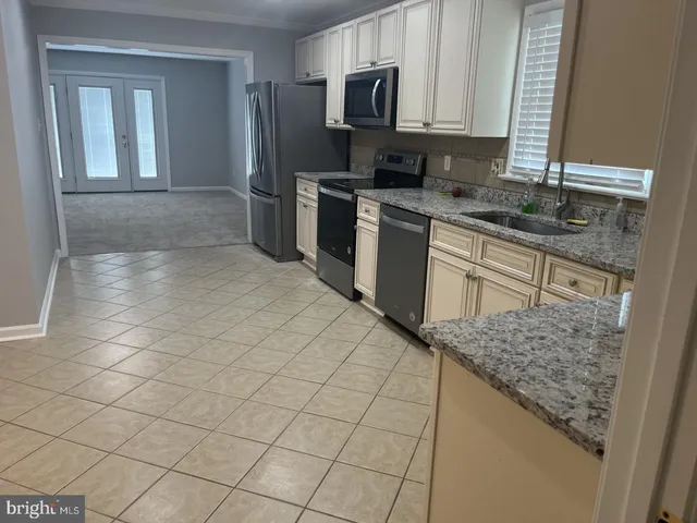 a kitchen with stainless steel appliances granite countertop a sink stove and cabinets
