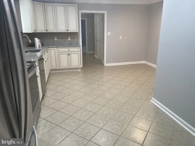a kitchen with a sink a refrigerator and cabinets